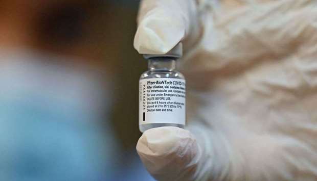 A health worker shows a vial of the Pfizer-BioNTech vaccine against Covid-19