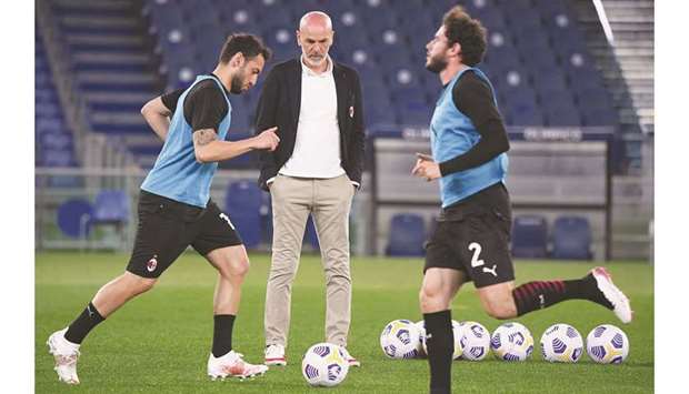 AC Milan coach Stefano Pioli (centre) watches his players warm up before the Serie A match against Lazio in Rome, Italy, on Monday. Lazio had won the match 3-0. (Reuters)