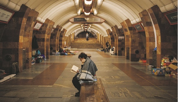 A woman reads a book as she and other residents take shelter from shelling in a metro station in Kharkiv.