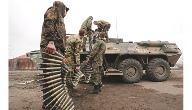 Service members of pro-Russian troops load ammunition into an armoured personnel carrier in the southern Ukraine port city of Mariupol.