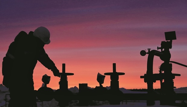 A worker checks the valve of an oil pipe at an oilfield owned by Russian state-owned oil producer Bashneft near the village of Nikolo-Berezovka, northwest of Ufa, Bashkortostan, Russia (file). Russia produced about 300,000 bpd below its target in March at 10.018mn bpd, according to a report based on secondary sources.