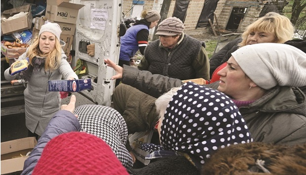 Volunteers distribute food to local residents in the village of Zalissya, northeast of Kyiv yesterday. The war is expected to slow growth and further increase inflation, the IMF said in its latest World Economic Outlook, while warning that its forecast was marked by u201cunusually high uncertainty.u201d