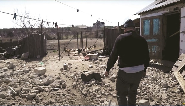 A resident walks among debris, amid Russiau2019s invasion, in Moshchun village, Kyiv region, Ukraine, in this still image taken from a video released yesterday.