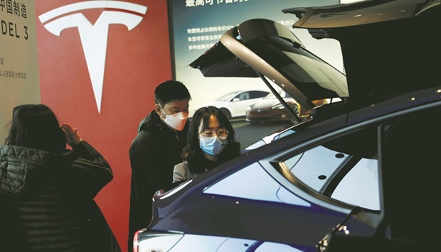 Visitors check a China-made Tesla Model Y SUV at its showroom in Beijing. The lockdowns and virus containment measures threaten to slow Chinau2019s economic growth this year to below the governmentu2019s 5.5% target, according to Bloomberg Economics.