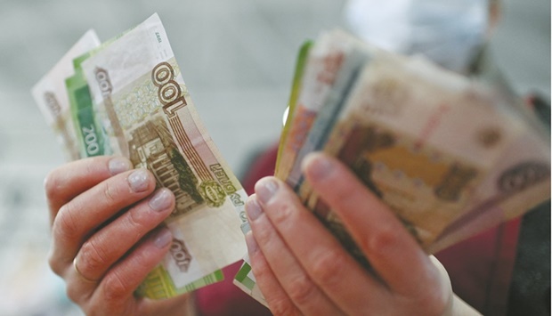 A vendor counts Russian rouble banknotes at a market in Omsk, Russia. Russia has slipped closer to a technical default after foreign banks declined to process about $650mn of dollar payments on its bonds, forcing it to offer roubles instead.