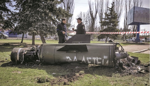 Ukrainian police inspect the remains of a large rocket with the words u2018for our childrenu2019 in Russian, next to the main building of a train station in Kramatorsk that was hit in a rocket attack, killing at least 50 people.