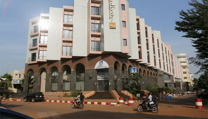 People drive motorcycles past the Radisson Blu hotel in Bamako, Mali