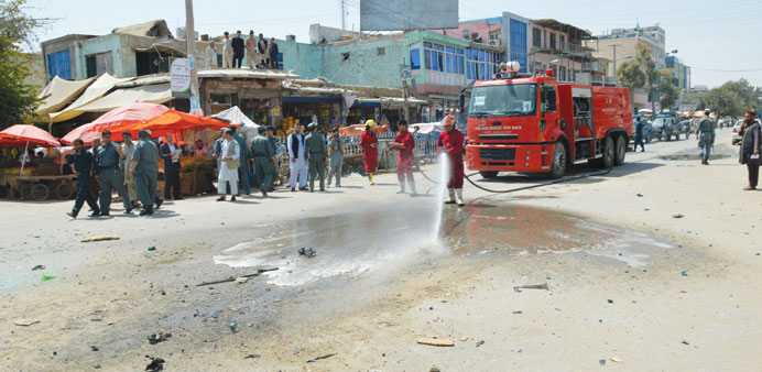 Afghan firefighters wash the site of a bomb attack that targeted a police vehicle in Kunduz. According to media reports, five people were injured, inc