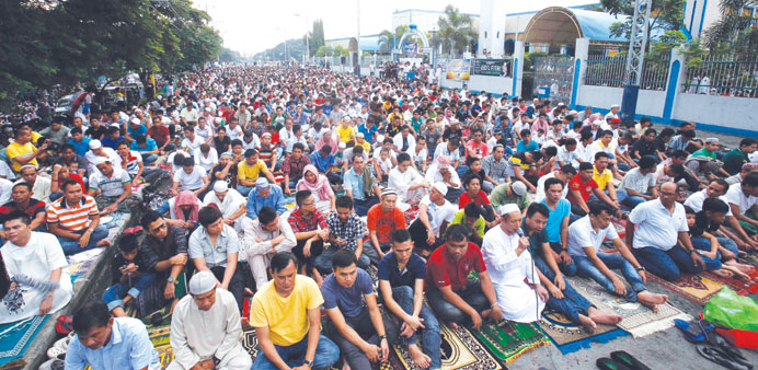 Filipino Muslims take part in morning prayers during Eid al-Fitr celebration along a road outside Blue Mosque in Taguig.