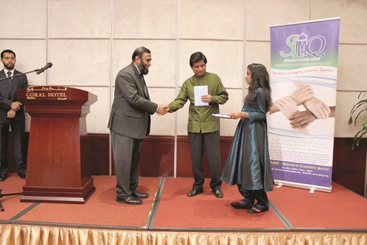 DISTINCTION: Hazim Hamza, President of SLMQ, presenting a shield to a student at a symposium.