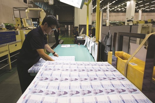 An employee inspects sheets of 1,000 won banknotes at the Korea Minting,  Security Printing & ID Card Operating Corp factory in Geyongsan, South Korea. The won closed up 0.9% to 1,182.68 per dollar yesterday.