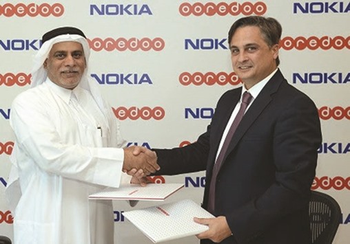 Yousuf Abdulla al-Kubaisi, chief operating officer, Ooredoo Qatar, and Najm shake hands after signing the pact.