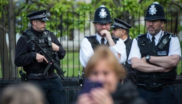 Tourists take photographs as armed police officers stand guard outside the Houses of Parliament in London last week.