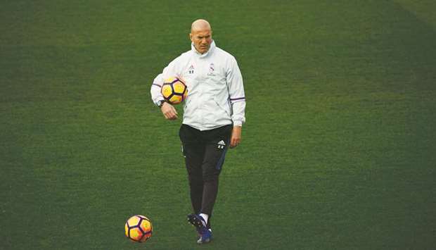 File picture of Real Madridu2019s French coach Zinedine Zidane walking on the pitch during a training session.