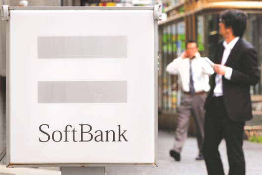 A sign bearing the SoftBank logo is displayed outside the companyu2019s store as pedestrians use their mobile phones in Tokyo. After ploughing about $2bn into minority stakes in Indian e-commerce businesses over the past few years, SoftBank is upping the stakes, looking to play consolidator and take a more active role at a trio of leading start-ups.