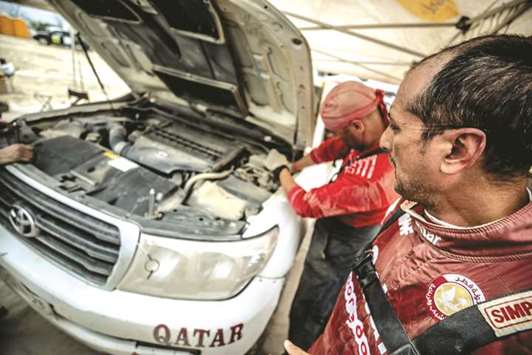 Qataru2019s Adel Abdulla watches his car getting worked on the third day of Rally Kazakhstan yesterday.