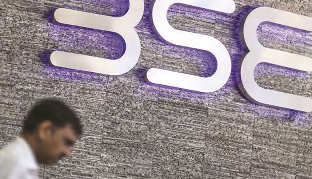 A man walks past the Bombay Stock Exchange (BSE) logo displayed outside the buildingu2019s lobby in Mumbai. India this month became the first among stock markets valued at more than a $1tn to hit a new peak this year as foreigners ploughed almost $10bn into local shares in 2019, the most among major Asian markets.