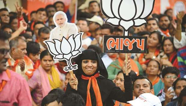 A supporter of Bharatiya Janata Party (BJP) holds a cutout of Prime Minister Narendra Modi as she attends a rally in Ahmedabad yesterday.