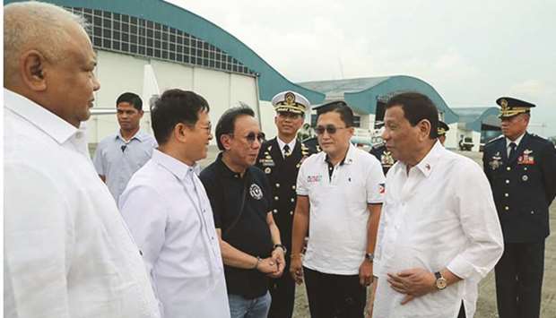 President Rodrigo Duterte, accompanied by senator-elect Christopher Lawrence u201cBongu201d Go, chats with some officials at Villamor Air Base in Pasay City before flying to Japan, yesterday.