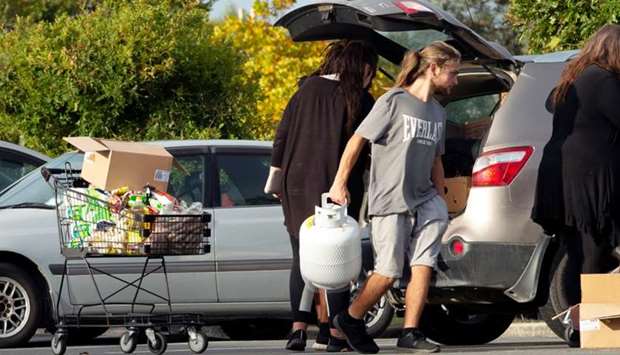 People take out products from their supermarket shopping cart and load them into their car outside Pak'nSave supermarket amid the spread of the coronavirus disease (Covid-19) in Christchurch, New Zealand, March 23