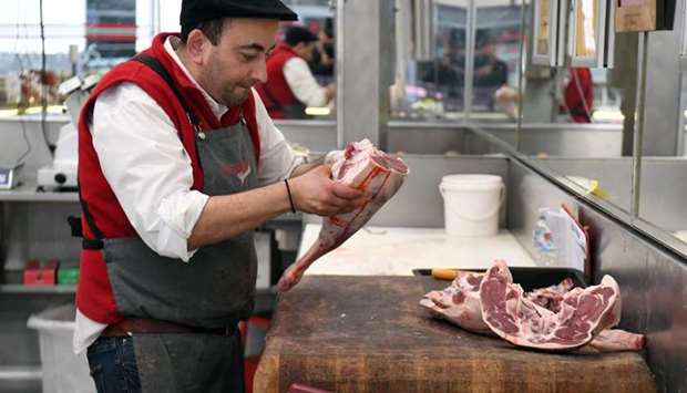 Butcher George Vourvahakis cuts up a leg of an Australian lamb at his store in the Melbourne suburb of Yarraville. China suspended imports from four major Australian beef suppliers May 12, just weeks after Beijing's ambassador warned of a consumer boycott in retaliation for Canberra's push to probe the origins of the coronavirus.