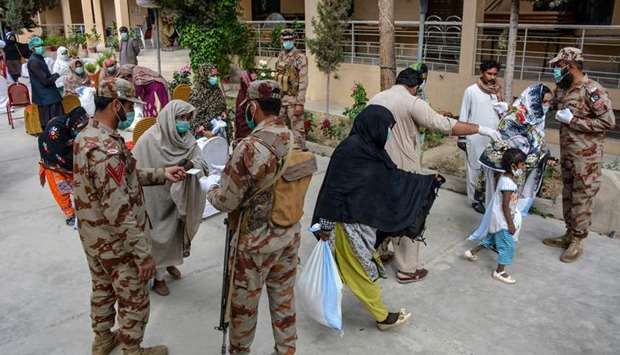 Frontier Corps personnel distribute food on a street in Quetta during a government-imposed nationwide lockdown.