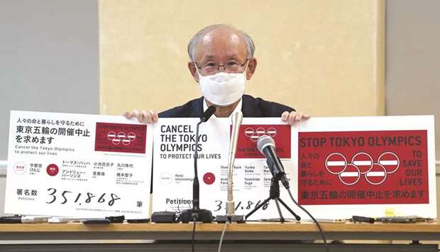 Lawyer Kenji Utsunomiya shows off placards as he attends a news conference after submitting a petition calling for the Tokyo 2020 Olympics to be cancelled to Tokyo Governor Yuriko Koike (not in picture) at the Tokyo Metropolitan Office Press Club in Tokyo.