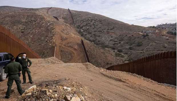 US border patrol agents stand near the location of halted construction along the U.S. Border wall with Mexico as an unfinished section is shown on Otay Mountain, east of San Diego, California, recently. (Reuters)