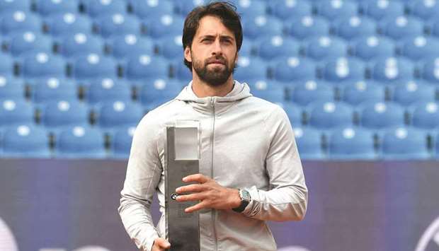 Georgiau2019s Nikoloz Basilashvili wears traditional Bavarian lederhosen as he celebrates with the trophy after winning the final against Germanyu2019s Jan-Lennard Struff in Munich yesterday. (AFP)