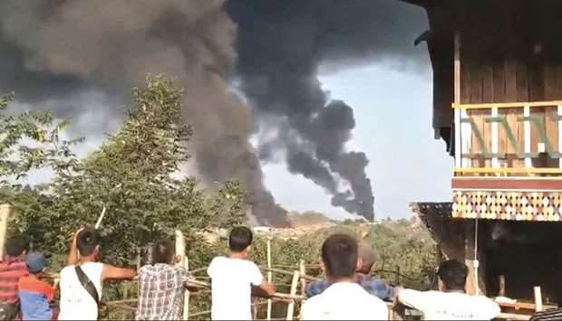 People look at thick columns of black smoke from Hkamti, Sagaing, Myanmar, in this picture obtained from social media.