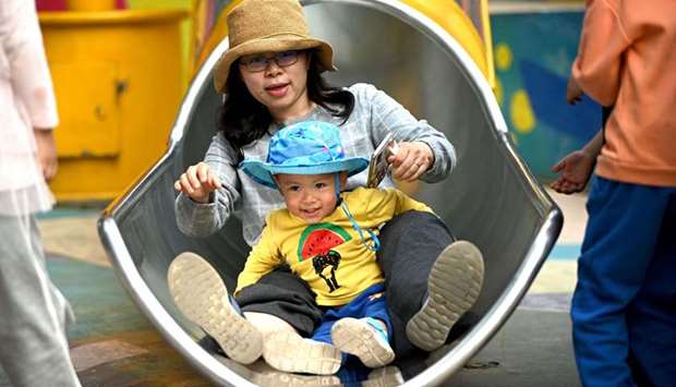 A mother and her baby playing on a slide at Wukesong shopping district in Beijing