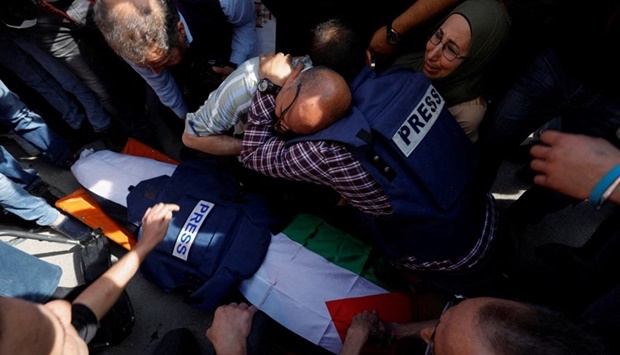 Mourners, including journalists, react next to the body of Al Jazeera reporter Shireen Abu Akleh who was killed by Israeli army gunfire.