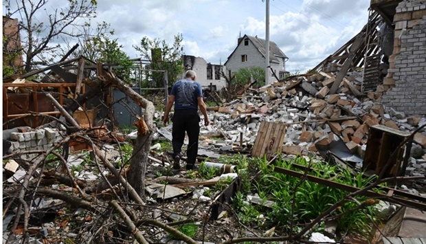 A local resident walks among debris in a yard of his destroyed house in the village of Mala Rogan, east of Kharkiv amid Russian invasion of Ukraine