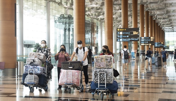 Travellers push their luggage though the departure hall at Changi Airport in Singapore. Over 6,600 jobs are available at the countryu2019s airport.