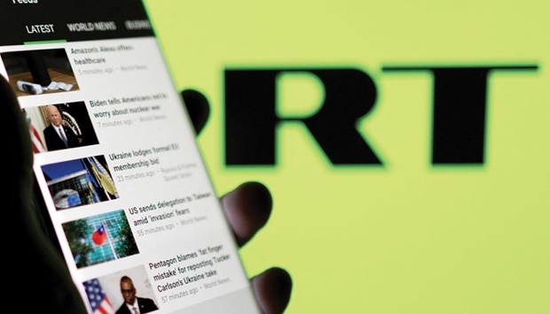 RT app is seen on a smartphone in front of their logo in this illustration taken in February. (Reuters)