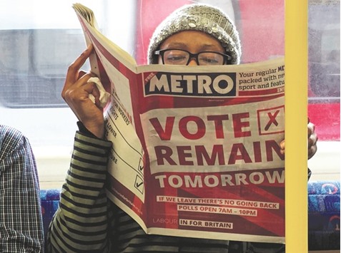 A woman reads a newspaper on the underground in London with a u2018vote remainu2019 advert for the Brexit referendum yesterday. The worldu2019s fifth-largest economy will suffer a powerful blow to growth and jobs if Britain becomes the first state to defect from the EU, corporate chiefs warned.