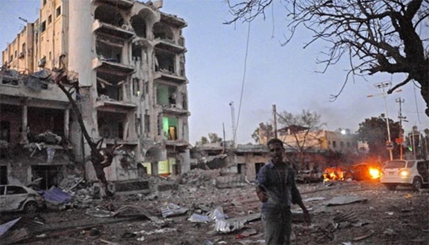 A man stands next to the Ambassador Hotel after al Shabaab launched a deadly attack, setting off a car bomb and fighting security forces inside the hotel complex.