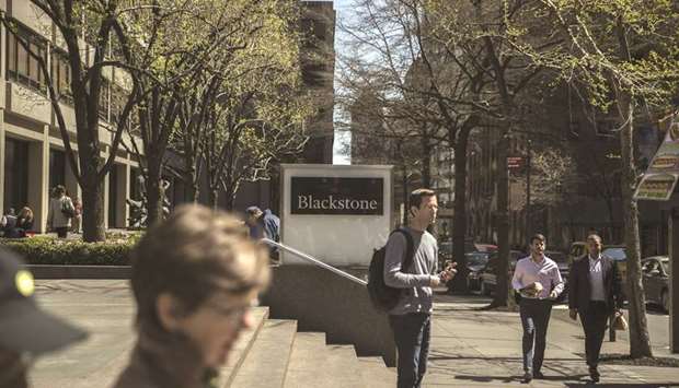 Pedestrians pass in front of Blackstone Group headquarters in New York. The largest real estate buyout of all time is set for its final chapter as Blackstone moves towards selling San Franciscou2019s landmark Ferry Building and two other properties.