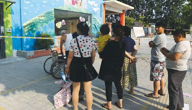 Residents stand outside the gate of a kindergarten, where an explosion occurred a day earlier, in Fengxian in Chinau2019s eastern Jiangsu province.