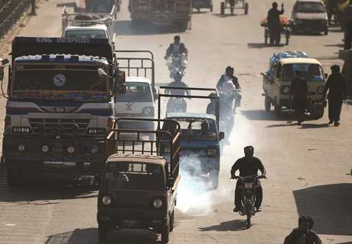 In this photograph taken on February 13, 2017, commuters drive on a busy street in Karachi.