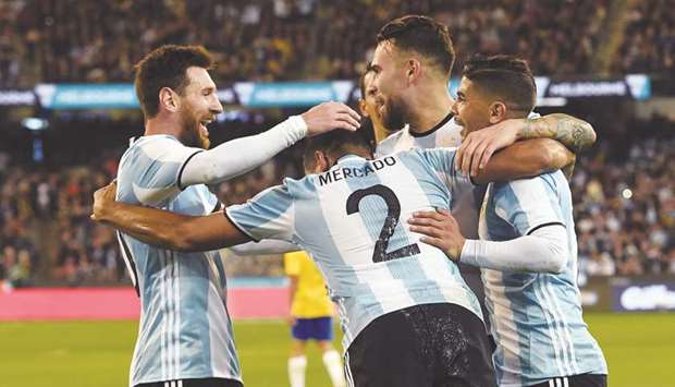 Argentinau2019s forward Lionel Messi (L) celebrates with teammate Gabriel Mercado (C) for his first goal during their friendly against Brazil at the MCG in Melbourne yesterday.