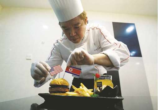 Chef Abraham Tan of Royal Plaza on Scottsu2019 Carousel restaurant puts finishing touches to his creation, the Trump Kim burger, in Singapore yesterday.