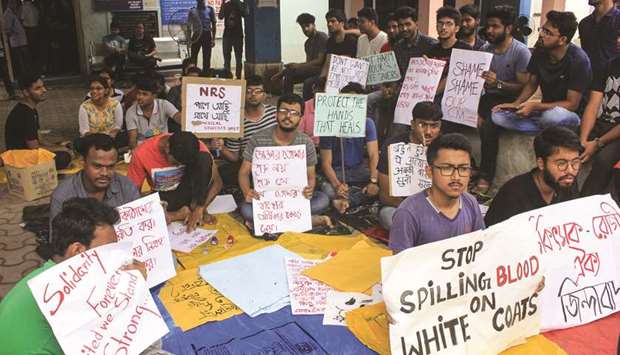 Junior doctors hold placards during a protest at North Medical College and Hospital in Siliguri, West Bengal, yesterday. The doctors, who are protesting against the assault on two of their colleagues at NRS Medical College and Hospital in Kolkata, have sought an unconditional apology from Chief Minister Mamata Banerjee and demanded adequate security and protection from the West Bengal government to meet to withdraw their protest.