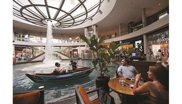 Customers of The Coffee Bean & Tea Leaf (right), look on as a boat moves along an indoor waterway in Marina Bay Sands in Singapore (file). Genesis Alternative Ventures, anchored by family office Sassoon Investment Corp, who brought Coffee Bean to Asia, plans to raise $70mn over the coming 12 months for venture debt financing, people familiar with the matter said.