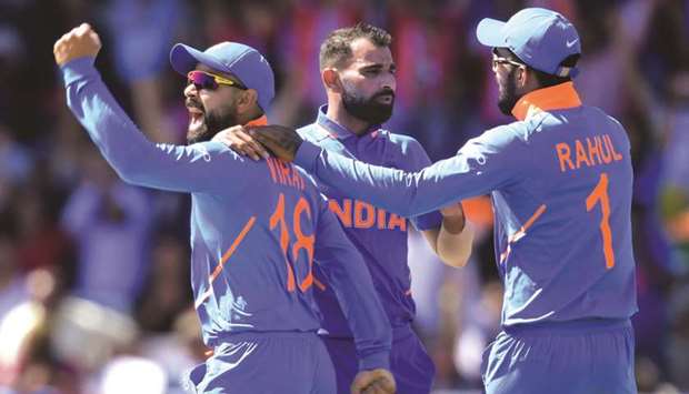 Indiau2019s Mohamed Shami (centre) celebrates with captain Virat Kohli (left) and teammate KL Rahul after taking the wicket of West Indiesu2019 Chris Gayle (not pictured) during the 2019 ICC Cricket World Cup match at Old Trafford in Manchester, United Kingdom, yesterday. (AFP)