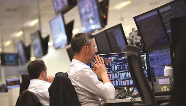 Traders monitor share prices at the London Stock Exchange. Londonu2019s benchmark FTSE 100 gained 0.1% to 7,220.22 points yesterday.