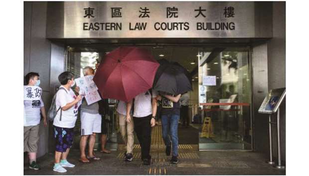 Defendants and supporters leave the Eastern District Court in Hong Kong yesterday after a group of defendants appeared in court on charges of illegally entering the Legislative Council government complex during protests on July 1, 2019.