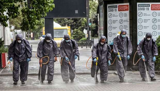 Municipal workers disinfect a deserted street in Baku.