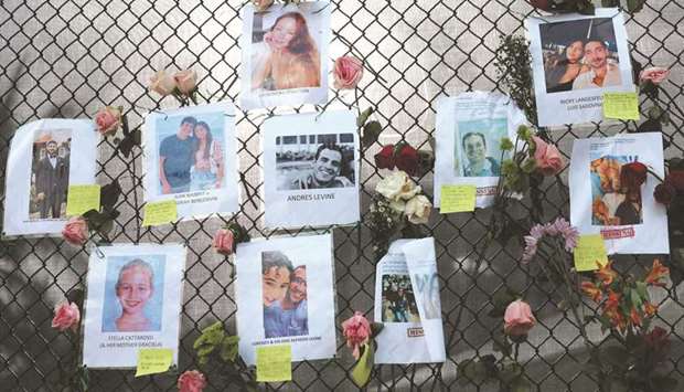 Pictures of some of the missing from the partially collapsed 12-story Champlain Towers South condo building hang on a fence in Surfside, Florida, yesterday. The pictures were placed on the fence as loved ones try to find them. Over 150 people are being reported as missing as search-and-rescue efforts continue with rescue crews from across Miami-Dade and Broward counties. (AFP)