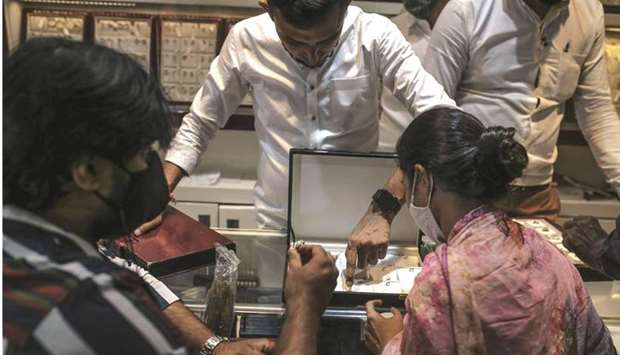 An employee attends to customers inside a jewellery store in Mumbai. The Securities and Exchange Board of India, the regulator appointed by the government, has proposed a new framework laying out the role of spot exchanges, assayers, vaults and traders for gold and the policy is open for public feedback till June 18.